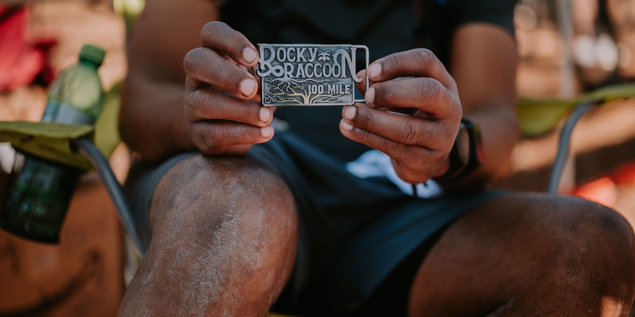 ultra marathon belt buckle held by runner